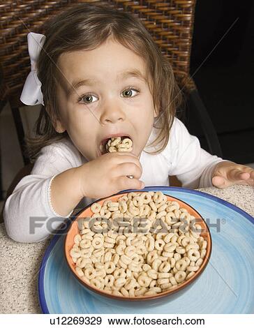 Stock Photo - Girl eating bowl of cereal. Fotosearch