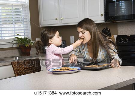 Picture - Girl feeding mother cookies. Fotosearch