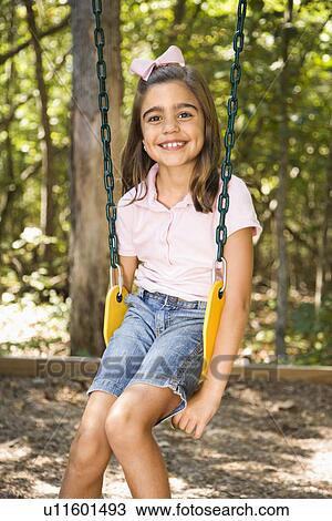 Girl sitting on swing smiling View Large Photo Image Stock Image - Girl sitting on swing smiling. Fotosearch