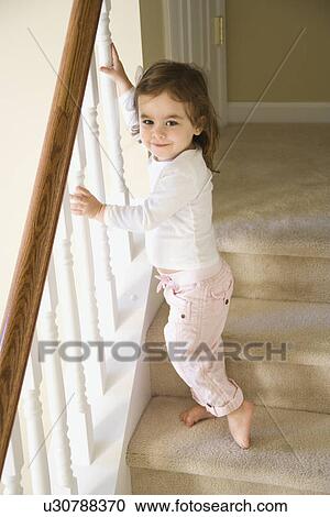 Girl standing on carpeted stairs holding onto railing View Large Photo Image Stock Image - Girl standing on carpeted stairs holding onto railing. Fotosearch