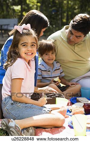 Girl with family picnicking in the park View Large Photo Image Stock Photo - Girl with family picnicking in the park. Fotosearch