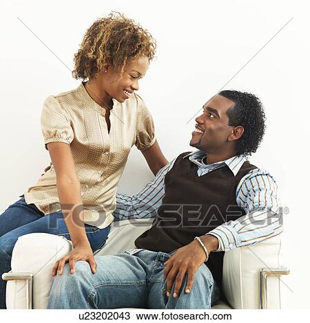 Happy couple sitting close together View Large Photo Image Stock Image - Happy couple sitting close together. Fotosearch