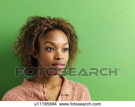 Head and shoulder portrait of young woman on green background. View Large Photo Image Picture - Head and shoulder portrait of young woman on green background.. Fotosearch