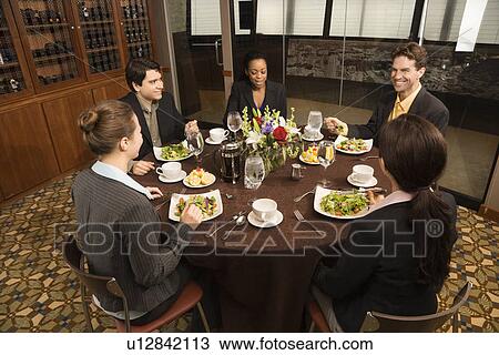 Stock Image - High angle of diverse group of businesspeople in restaurant eating. Fotosearch