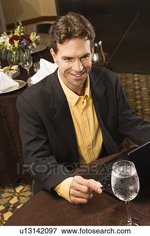 High angle view of businessman with laptop in restaurant View Large Photo Image Stock Photo - High angle view of businessman with laptop in restaurant. Fotosearch