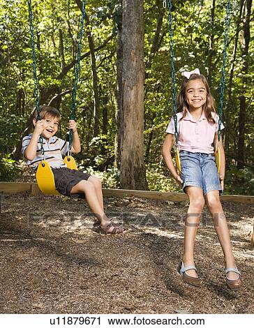 Hispanic boy and girl on swing set smiling at viewer. View Large Photo Image Stock Image - Hispanic boy and girl on swing set smiling at viewer.. Fotosearch