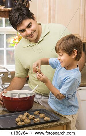 Hispanic father and son in kitchen making cookies. View Large Photo Image Stock Photo - Hispanic father and son in kitchen making cookies.. Fotosearch