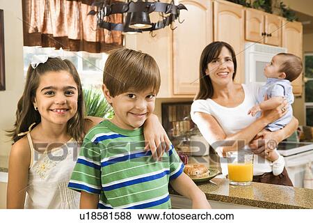 Hispanic mother and children smiling at viewer in kitchen. View Large Photo Image Stock Photo - Hispanic mother and children smiling at viewer in kitchen.. Fotosearch