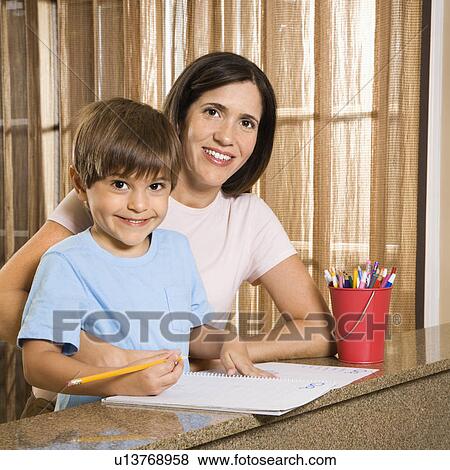 Stock Photo - Hispanic mother and son with homework smiling at viewer.. Fotosearch