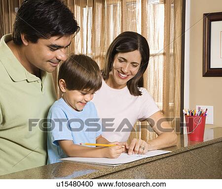 Stock Image - Hispanic parents helping son with homework.. Fotosearch