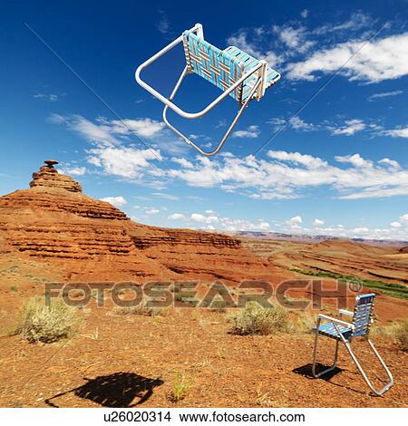 Lawn chair thrown in midair in scenic desert landscape with land formation. View Large Photo Image Picture - Lawn chair thrown in midair in scenic desert landscape with land formation.. Fotosearch