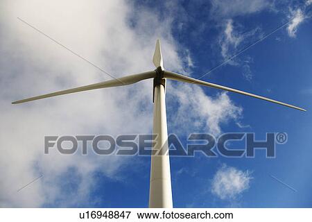 Low angle view of wind turbine against blue sky and clouds. View Large Photo Image Stock Photo - Low angle view of wind turbine against blue sky and clouds.. Fotosearch