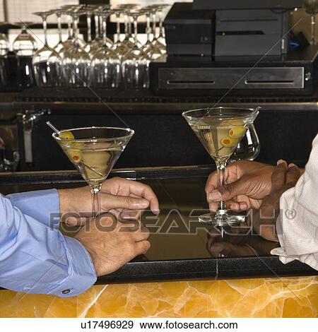Male hands holding martinis at bar View Large Photo Image Stock Photo - Male hands holding martinis at bar. Fotosearch