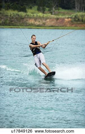 Male wakeboarding on lake View Large Photo Image Stock Photograph - Male wakeboarding on lake. Fotosearch