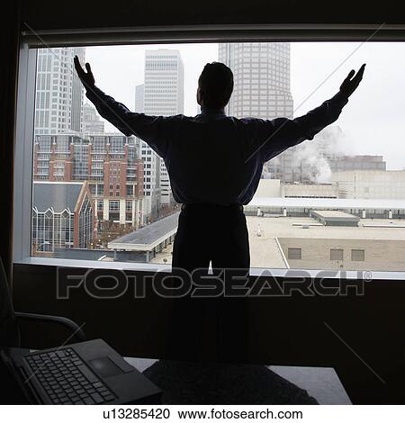 Male with raised arms in office with skyline in background View Large Photo Image Stock Image - Male with raised arms in office with skyline in background. Fotosearch