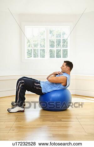 Stock Photo - Man doing sit ups on balance ball. Fotosearch