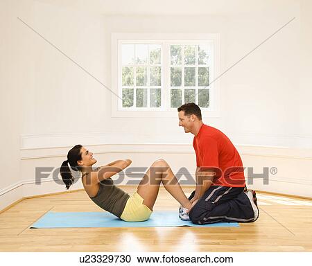Man holding woman's feet down as she does sit up exercises View Large Photo Image Stock Image - Man holding woman's feet down as she does sit up exercises. Fotosearch