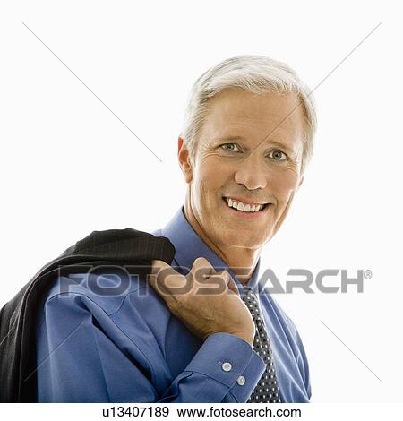 Stock Photo - Man in business suit smiling at viewer with jacket draped over shoulder. Fotosearch