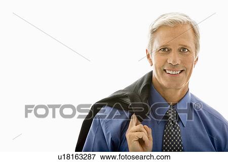 Stock Photo - Man in business suit smiling at viewer with jacket draped over shoulder. Fotosearch