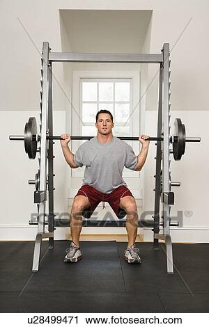 Man lifting weights in gym. View Large Photo Image Stock Image - Man lifting weights in gym.. Fotosearch