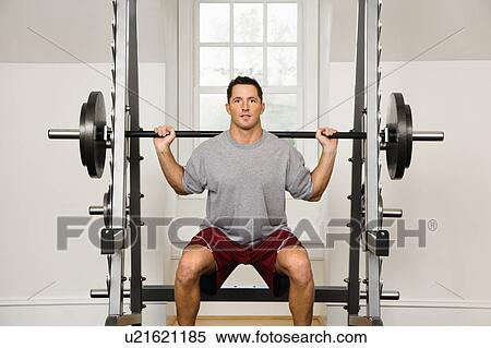 Stock Photography - Man lifting weights in gym.. Fotosearch