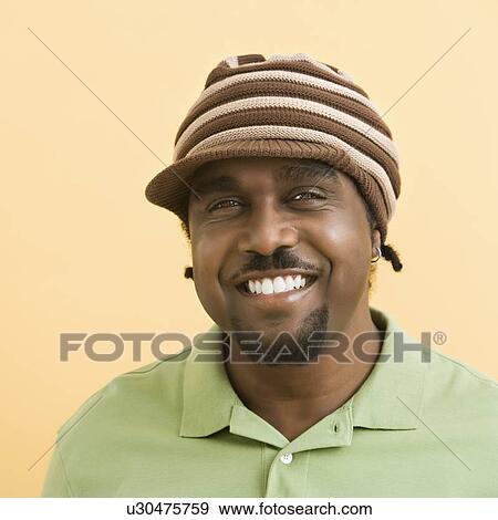 Stock Photo - Man wearing knit hat with brim . Fotosearch
