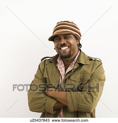 Mid-adult man wearing hat and smiling at viewer with arms crossed View Large Photo Image Stock Image - Mid-adult man wearing hat and smiling at viewer with arms crossed. Fotosearch