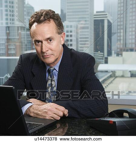 Middle-aged Caucasian male in office with skyline in background. View Large Photo Image Stock Photo - Middle-aged Caucasian male in office with skyline in background.. Fotosearch