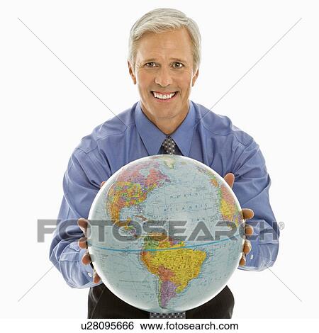Stock Photograph - Middle aged Caucasian man holding globe towards viewer.. Fotosearch