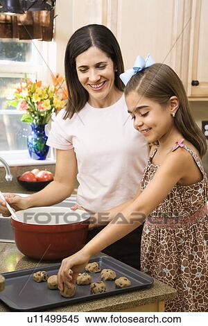 Stock Photography - Mother and daughter in kitchen making cookies. Fotosearch