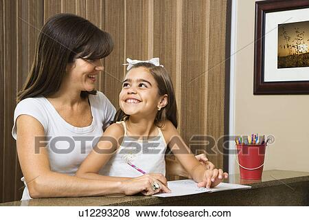 Mother helping daughter making eye contact and working on homework View Large Photo Image Stock Photo - Mother helping daughter making eye contact and working on homework. Fotosearch