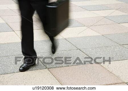 Motion blur of businessman legs walking outdoors with briefcase. View Large Photo Image Stock Photo - Motion blur of businessman legs walking outdoors with briefcase.. Fotosearch