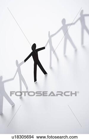 Picture - One black cutout paper person holding hands with group of white people. Fotosearch