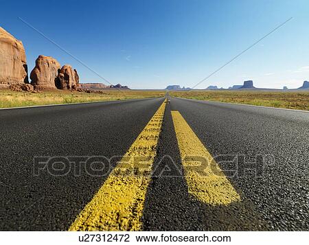 Open highway in scenic desert landscape with distant mountains and butte land formations View Large Photo Image Stock Image - Open highway in scenic desert landscape with distant mountains and butte land formations. Fotosearch