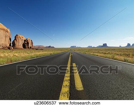 Open highway in scenic desert landscape with distant mountains and butte land formations. View Large Photo Image Stock Photo - Open highway in scenic desert landscape with distant mountains and butte land formations.. Fotosearch