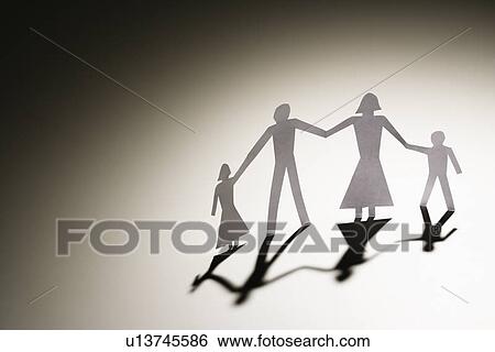 Stock Photograph - Paper cutout family of four standing holding hands.. Fotosearch