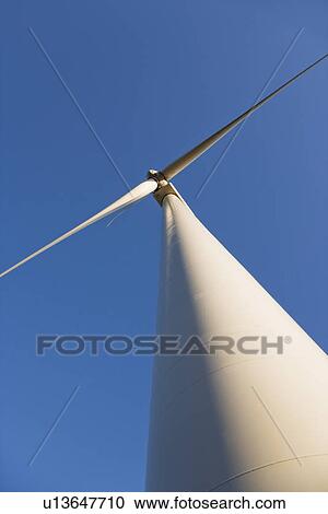 Perspective shot of wind turbine against blue sky View Large Photo Image Stock Image - Perspective shot of wind turbine against blue sky. Fotosearch