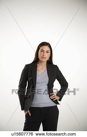 Stock Photograph - Portrait of Caucasian mid adult professional business woman standing with hand on hip looking at viewer.. Fotosearch