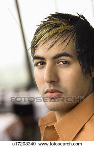Stock Image - Portrait of Hispanic mid adult man looking at viewer.. Fotosearch