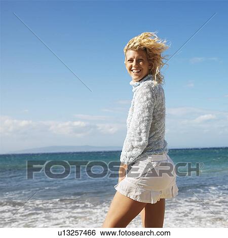 Stock Photograph - Portrait of pretty young blond woman on Maui, Hawaii beach smiling.. Fotosearch