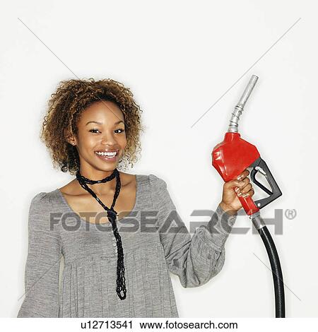 Portrait of pretty young woman smiling holding gas pump nozzle on white background. View Large Photo Image Stock Image - Portrait of pretty young woman smiling holding gas pump nozzle on white background.. Fotosearch