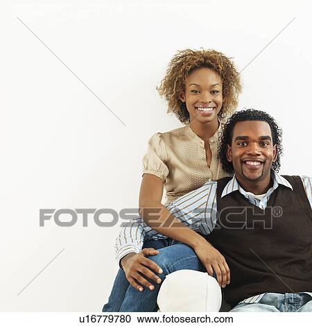 Portrait of smiling happy young couple sitting close together. View Large Photo Image Stock Image - Portrait of smiling happy young couple sitting close together.. Fotosearch