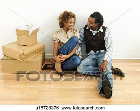 Portrait of smiling happy young couple sitting on floor of home with moving boxes View Large Photo Image Stock Photograph - Portrait of smiling happy young couple sitting on floor of home with moving boxes. Fotosearch