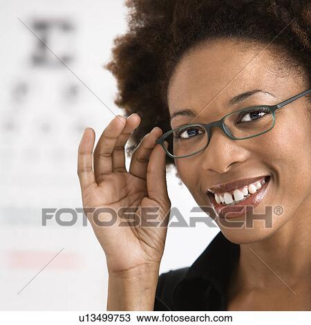 Portrait of woman with afro wearing eyeglasses with medical eyechart in background. View Large Photo Image Stock Image - Portrait of woman with afro wearing eyeglasses with medical eyechart in background.. Fotosearch
