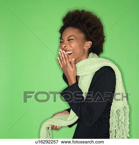 Pretty woman wearing green scarf laughing against green background. View Large Photo Image Stock Photo - Pretty woman wearing green scarf laughing against green background.. Fotosearch