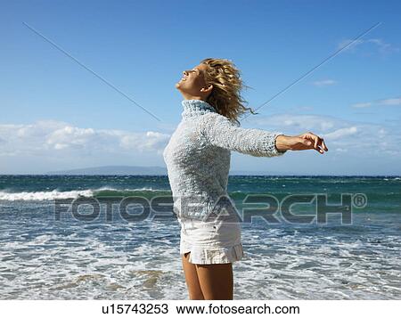Pretty young blond woman standing on Maui, Hawaii beach with arms out to side and wind blowing hair smiling. View Large Photo Image Stock Image - Pretty young blond woman standing on Maui, Hawaii beach with arms out to side and wind blowing hair smiling.. Fotosearch