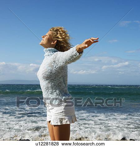 Pretty young blond woman standing on Maui, Hawaii beach with arms out to side and wind blowing hair smiling. View Large Photo Image Stock Photo - Pretty young blond woman standing on Maui, Hawaii beach with arms out to side and wind blowing hair smiling.. Fotosearch