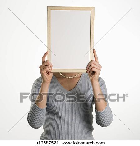 Professional business woman holding up blank dry erase board in front of her face View Large Photo Image Stock Image - Professional business woman holding up blank dry erase board in front of her face. Fotosearch