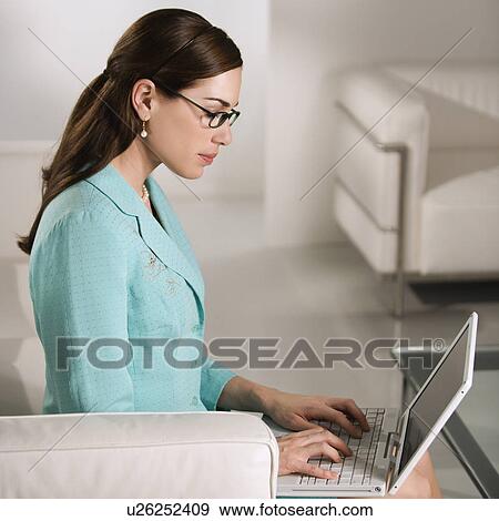 Profile of Caucasian mid adult professional business woman sitting in modern office working on laptop computer. View Large Photo Image Stock Photo - Profile of Caucasian mid adult professional business woman sitting in modern office working on laptop computer.. Fotosearch