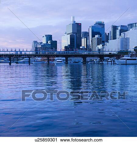 Stock Image - Pyrmont Bridge over Darling Harbour with skyscrapers in Sydney, Australia.. Fotosearch